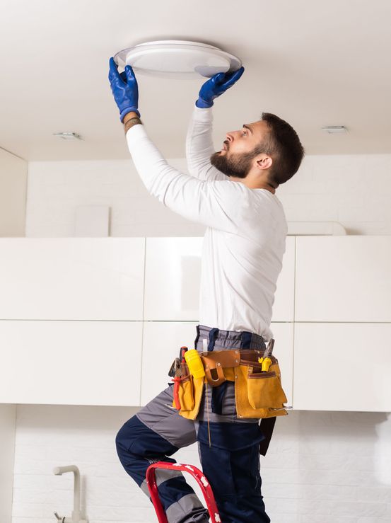 Handyman fixing ceiling light